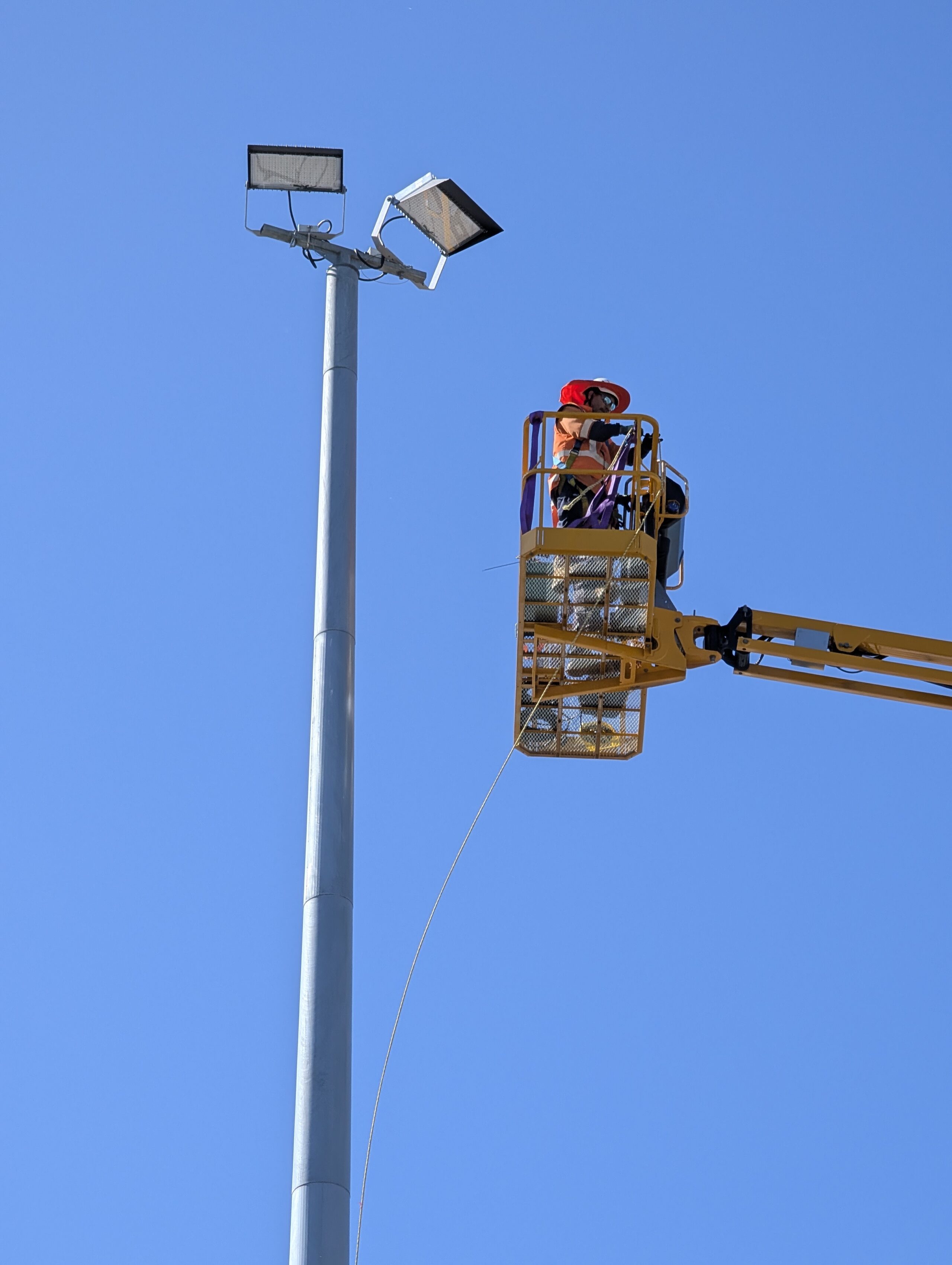 connetics workers on crane lift on apron of christchurch airport