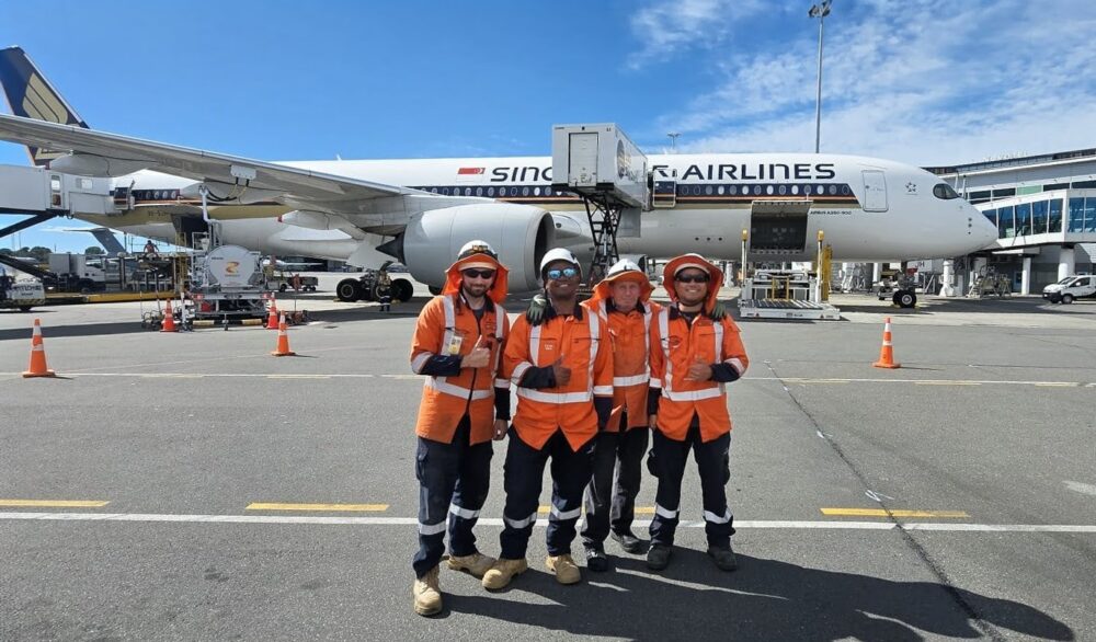 Our lighting team in front of a plane on the Christchurch airport apron